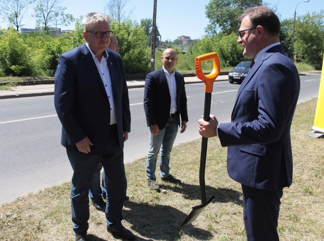 Prezydent Radomia Radosław Witkowski przekazuje łopatę przedstawicielowi wykonawcy ważnej trasy drogowej w mieście.