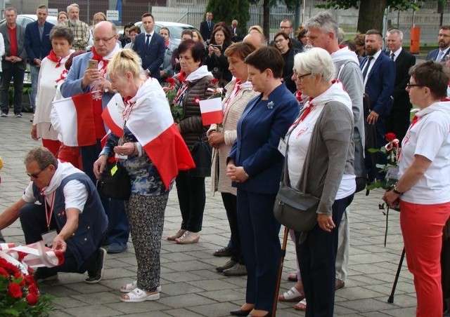 Członkowie Stowarzyszenia Rodzin Polskich Ofiar Obozów Koncentracyjnych wspólnie z wicepremier Beatą Szydło składają kwiaty przed tablicą upamiętniająca polskich więźniów z I transportu do KL Auschwitz