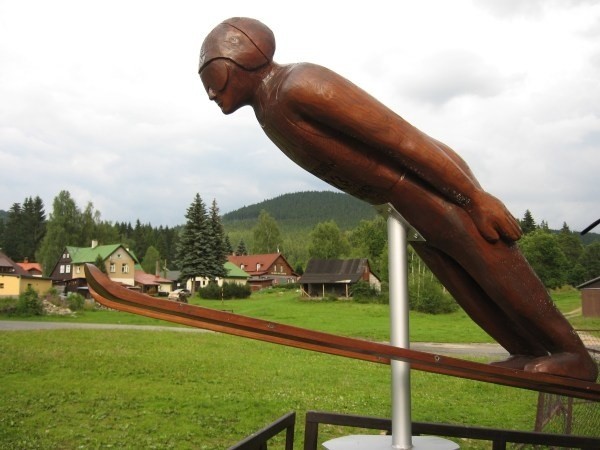 Drewniana rzeźba skoczka pod skoczniami w Harrachovie jest...