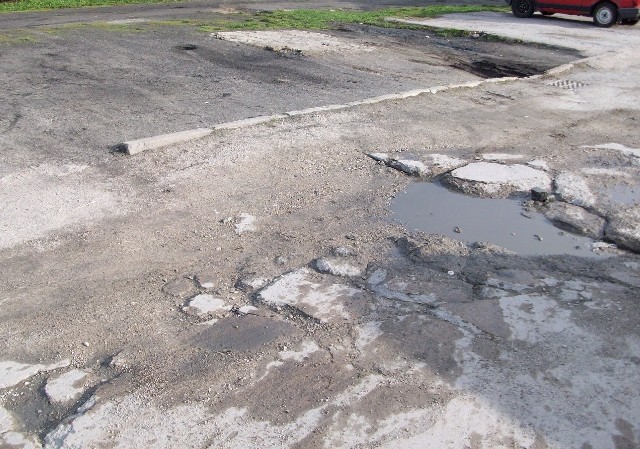 Na ul. Henryka V Żelaznego miejsca parkingowe są usiane kraterami, a betonowa droga dojazdowa jest w ruinie.