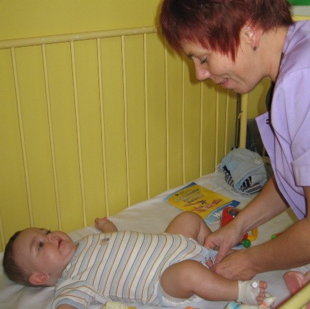 Pielęgniarka oddziału dziecięcego Małgorzata Rosiak przewija małego pacjenta Kacperka. Czy w nowym szpitalu znajdzie się dla niej miejsce?