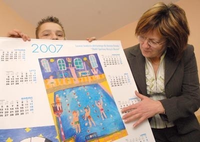 Dyrektorka domu dziecka Arleta Rupenthal i wychowanek prezentuja kalendarz z najlepszymi pracami