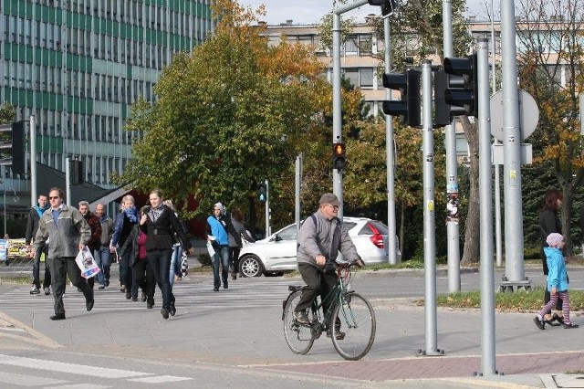 Piesi biegną przez dwie jezdnie ulicy IX Wieków Kielc na wysokości Urzędu Wojewódzkiego, aby zdążyć przejść na zielonym świetle przez trzecia jezdnie, ale jest to niemożliwie. Światło świeci się za krótko