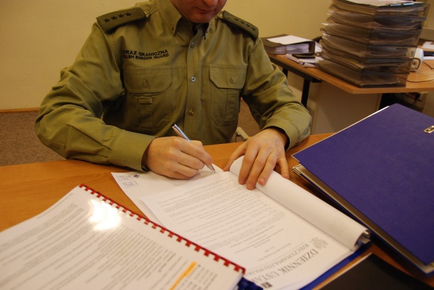 Funkcjonariusz Straży Granicznej sprawdza dokumentację...
