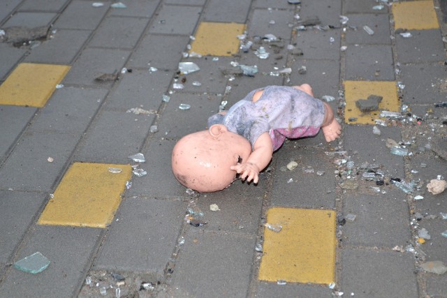 Lalka leżąca przed jednym z ostrzelanych przez Rosjan bloków