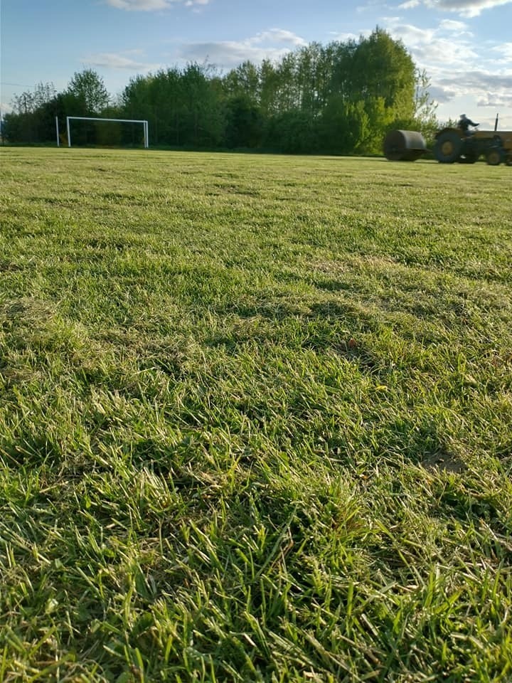 Piłkarze i trener Arki przygotowywali do treningów boisko w Kałkowie - kosili trawę, wałowali murawę, malowali linie [ZDJĘCIA]
