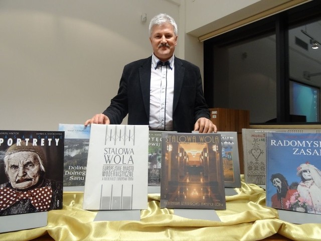 Marek Stańkowski na spotkaniu z mieszkańcami w bibliotece, z albumami, jakie wydał na temat architeltury Stalowej Woli.