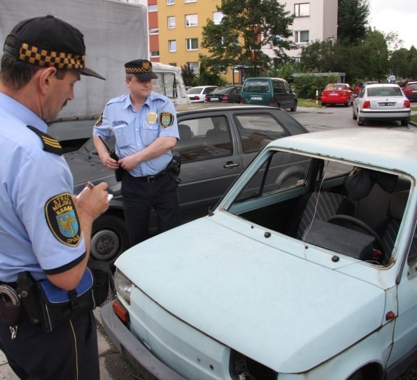 Starszy inspektor Mieczysław Krzyszczuk i Mirosław Koczanowski oglądali wczoraj porzuconego malucha przy ul. Szarych Szeregów. Wrak odholują na strzeżony parking pracownicy MZD.