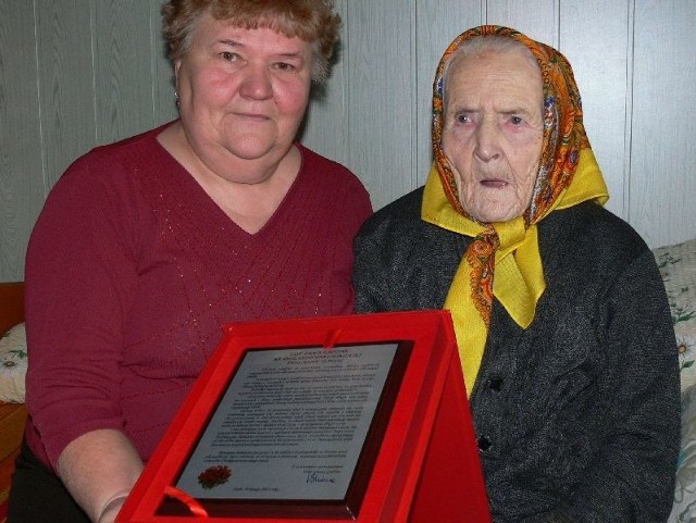 Najmłodsza córka Emilia z mamą i pamiątkowy grawerton, który z okazji 100 urodzin, jubilatka dostała od władz gminy.