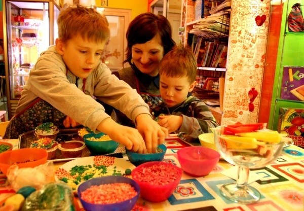 Podczas urodzinek warsztatowych dzieci kolorowymi dodatkami zdobią ciasteczka i babeczki.
