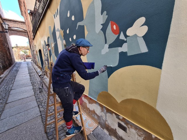 Przy ul. Ciasnej w Toruniu trwają prace nad nowym muralem. Znikną wulgaryzmy, które od lat "upiększały" jedną z najbardziej znanych uliczek starówki. Autorem muralu jest Andrzej Poprostu, toruński artysta.