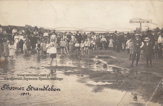 Ta piękna fotografia  została najprawdopodobniej wykonana 9 lub 10 sierpnia 1911 roku. Widać na niej mieszkańców Torunia, którzy po gorącej przerwie mogli wrócić na swoją ulubioną plażę. Raduje się z tego m.in. Wiktoria Mączkowska, dama w wielkim kapeluszu i narysowanym nad nim krzyżykiem