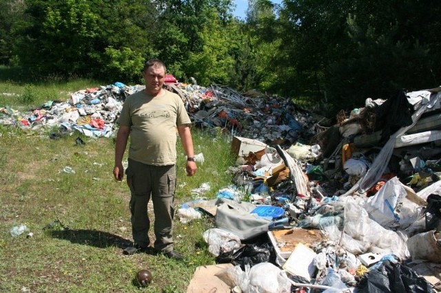 Wojciech Modzelewski pokazuje śmieci w lesie w Zakrzewie