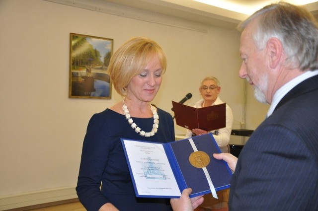 Dr Izabela Kowacka, wiceprezes d.s. lecznictwa w Klinice Uzdrowiskowej "Pod Tężniami" im. Jana Pawła II  odbiera medal z rąk Mariana Gawineckiego, prezesa TPC. w głębi Klara Drobiewska, sekretarz TPC