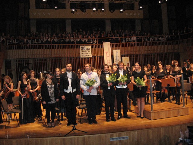 Tak wyglądał finał koncertu: przed orkiestrą stoją wykonawcy:od lewej:Przemysław Zych,Bartosz Kołsut, Adrian Hanke, Michal Drewnowski i Maria Wrzesińska, dyrygent kilku chórów.
