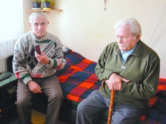 Kazimierz Kaliszewski pokazuje telefon, którym zrobił zdjęcie przywiązanej pensjonariuszki, obok Tadeusz Kruszyński