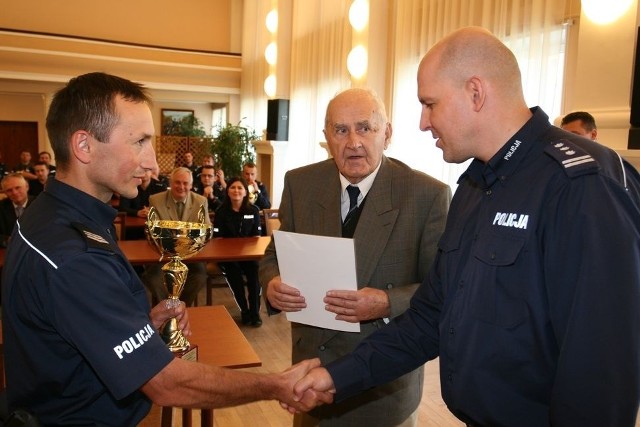 Sierż. szt. Tomasz Mysiak (z lewej) odbiera gratulacje z rąk komendanta wojewódzkiego insp. Michała Domaradzkiego.