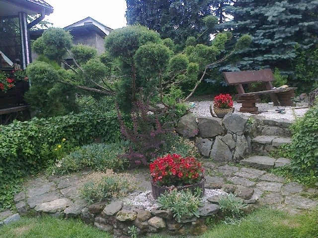 W ogrodzie Katarzyny Plucińskiej króluje styl naturalistyczny, a elementami dekoracyjnymi są kamień, drewno, wiklina. Nie ma tu miejsca na plastik.
