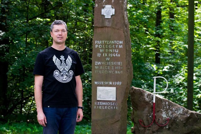 Wójt gminy Sitkówka-Nowiny Sebastian Nowaczkiewicz przed pomnikiem w Szewcach.