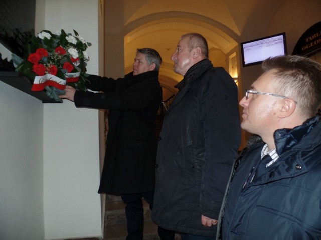 Kwiaty pod tablicą składają wiceprezydent, Karol Semik i Przemysław Bednarczyk.
