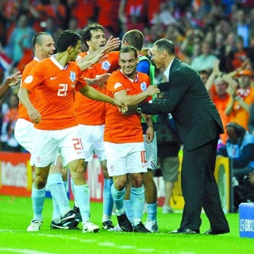 Selekcjoner reprezentacji Holandii Marco van Basten składa gratulacje strzelcowi drugiego gola dla drużyny Wesley'owi Sneijderowi.