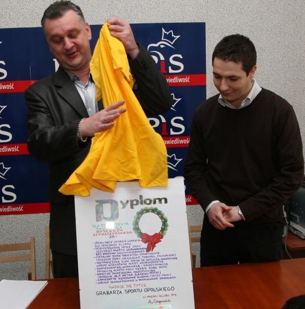 Arkadiusz Szymański (z lewej) i Patryk Jaki pokazują dyplom "grabarza opolskiego sportu", który zamierzają wręczyć Ryszardowi Zembaczyńskiemu.
