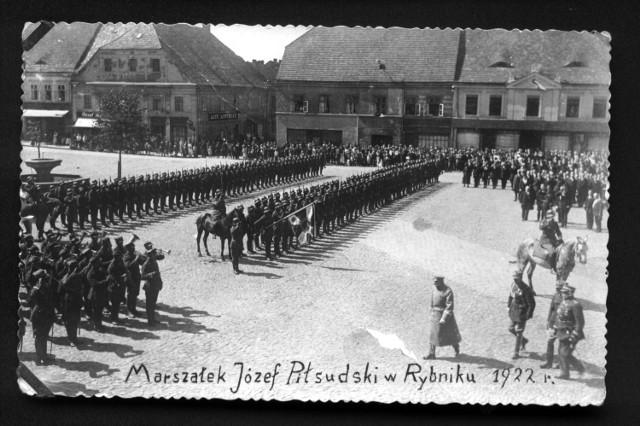 Rynek w Rybniku. Niewielu mieszkańców Rybnika wie, na pamiątkę jakiego wydarzenia wiele lat temu w płytę rynku wmurowano pamiątkową tablicę. Upamiętnia ona 28 sierpnia 1922 r., kiedy to do miasta przyjechał marszałek Józef Piłsudski.  To była sensacja. Piłsudski przyjechał samochodem. Odbyła się msza polowa, a potem wspaniała defilada wojskowa. Dekorowano odznaczeniami państwowymi. Wizyta Piłsudskiego była nobilitacją dla Rybnika, spędził na Śląsku tylko trzy dni i odwiedził raptem sześć miast. Po wizycie na rynku zapraszamy na spacer odnowionym, rybnickiej deptakiem, ulicy ulicami Sobieskiego i Powstańców Śląskich...