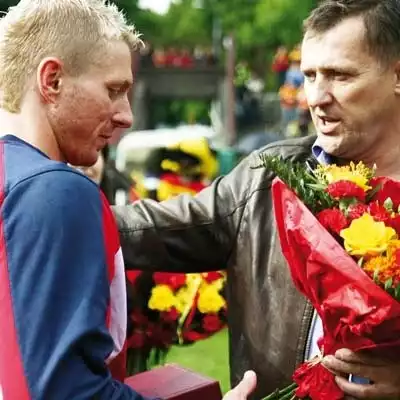 Mariusz Dzienis (z lewej) na pożegnanie otrzymał od Cezarego Kuleszy bukiet żółto-czerwonych kwiatów