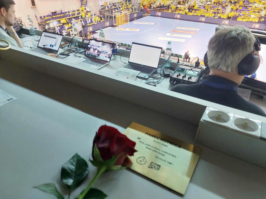 Czerwona róża przy tabliczce upamiętniającej Pawła Kotwicę w...