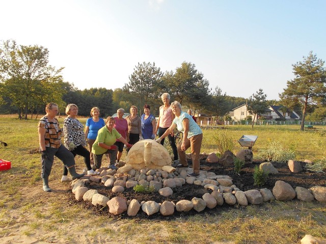 Grupa mieszkańców wsi Rudki pracuje przy zagospodarowaniu placu w centrum miejscowości. Stanęła tam już rzeźba żółwia.