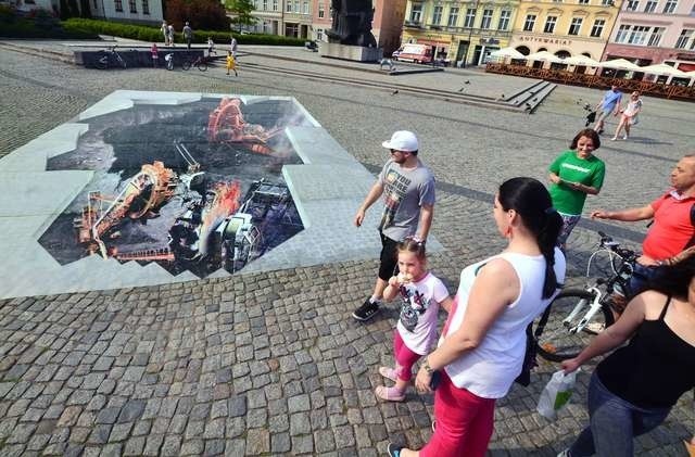 Grafika autorstwa Ryszarda Paprockiego rozłożona jest na płycie Starego RynkuPrace na Starym Rynku