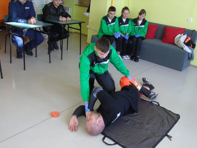 Uczestnik turnieju daje pokaz udzielania pierwszej pomocy i ułożenia poszkodowanego w pozycji w bocznej ustalonej