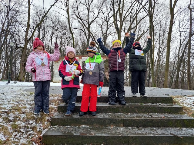 Dzieci z Warki uczestniczące w feryjnych zajęciach z Dworkiem na Długiej poznają tajniki zimowych dyscyplin sportowych. Tu uczestnicy konkurencji saneczkowych w parku Winiary.
