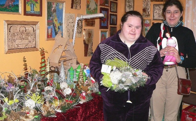 Agnieszka Pierścińska i Klaudia Wojciechowska prezentują prace na kiermaszu bożonarodzeniowym w buskich Warsztatach Terapii Zajęciowej.