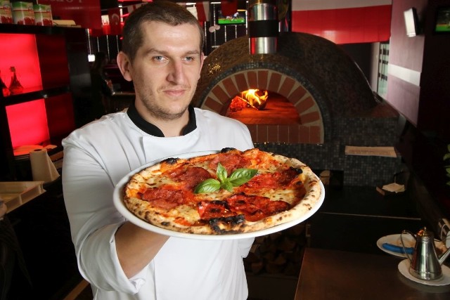 Krzysztof Lewczuk prezentuje pizzę, którą właśnie wyjął z pieca, w którym piekła się w temperaturze 400 stopni!
