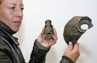 Archeolog Anna Leciejewska z fragmentami ceramiki - m.in. zagadkowym uchwytem naczynia - z osady z III - IV w. Fot. Anna Kaczmarz