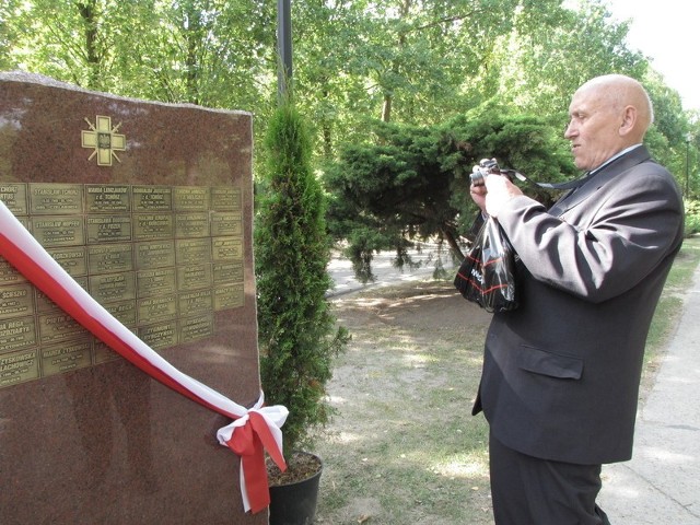 Henryk Jarmołowicz fotografuje tabliczki z nazwiskami swoich nieżyjących rodziców. Gdy był z nimi deportowany do Ałtajskiego Kraju, miał zaledwie trzy lata. 