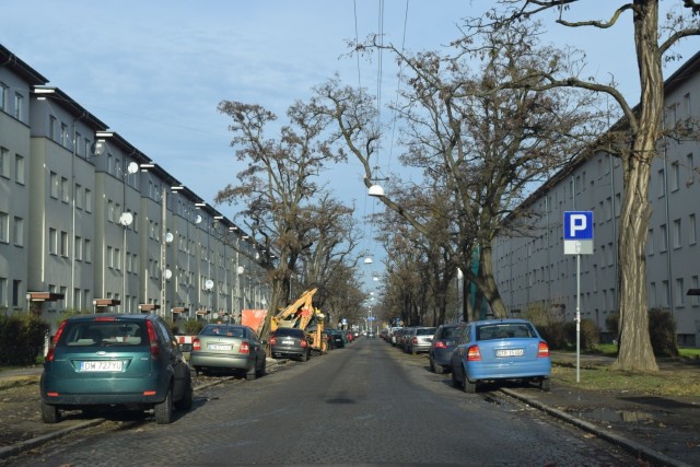 Ulica Górnicza jest zastawiona przez parkujące samochody i ciężki sprzęt budowlany