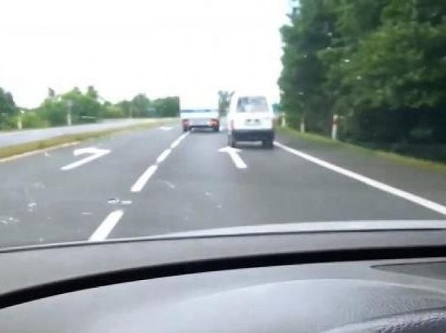 Radiowóz wyprzedza na skrzyżowaniu, korzystając z pasa do skrętu w lewo