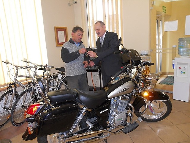 Zbigniew Sadowski (z lewej) odbiera w aleksandrowskim banku wylosowany motocykl. Kluczyki wręcza  Józef Szmelter, prezes zarządu KBS.