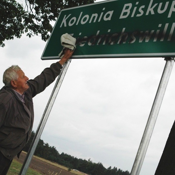 Zniszczona tablica przy wjeździe do Kolonii Biskupskiej.