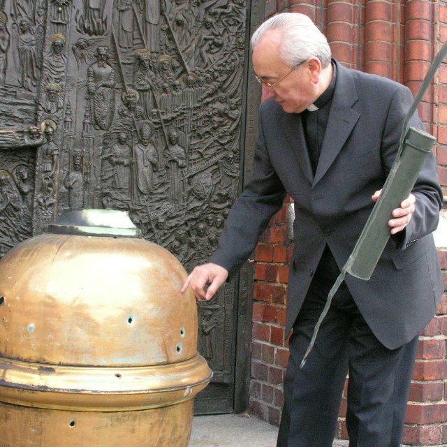 Kulę z otworami po pociskach i znalezioną wewnątrz tubę z dokumentami prezentuje ks. infułat Edmund Podzielny, proboszcz katedry.