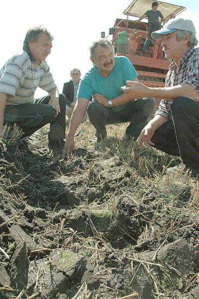 Waldemar Fiedorowicz (od lewej) i Ryszard Kamiński mówią, że na pole przy wale wjadą maszynami dopiero, gdy ziemia się osuszy. Wiesław Gwizdek ma więcej szczęścia &#8211; jego pole jest daleko od rzeki.