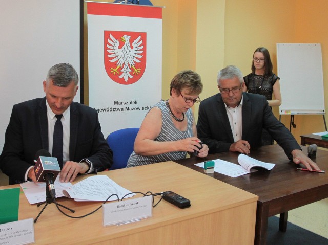 Rafał Rajkowski (z lewej) i burmistrz Skaryszewa Ireneusz Kumięga (z prawej) podpisują porozumienie o dofinansowaniu.
