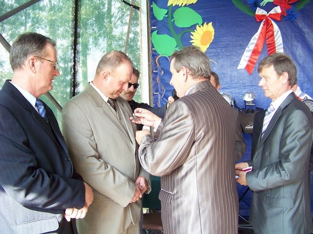 Stanisław Adamczyk, wójt gminy Kowal, wręcza odznaczenie Karolowi Pałaszewskiemu. Z lewej Jan Rybacki, sołtys Dziardonic.