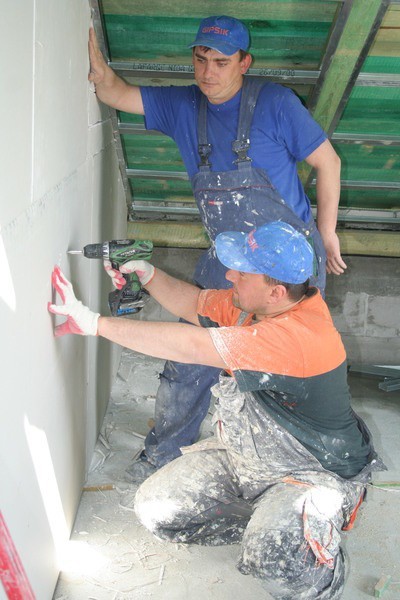 Pod więźbą dachowa pomieszczenia przygotowują MarcinZawada (kuca) i Adam Zamyślewski z firmy "PIK&#8221; w Grudziądzu, podwykonawcy remontu kijewskiego kompleksu