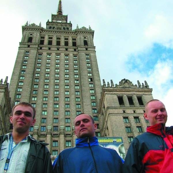 Tarnobrzescy strażacy na tle Pałacu Kultury i Nauki.