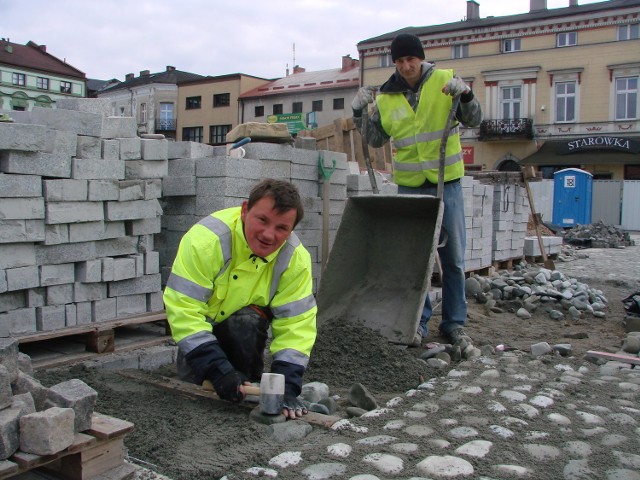 Daniel Hałat i Marcin Kiełtyka pracują przy remoncie Rynku. Od kilku dni zajmują się uszczelnianiem i układaniem otoczaków (kamienie).  Skończą do maja. To jeden z ostatnich etapów inwestycji.