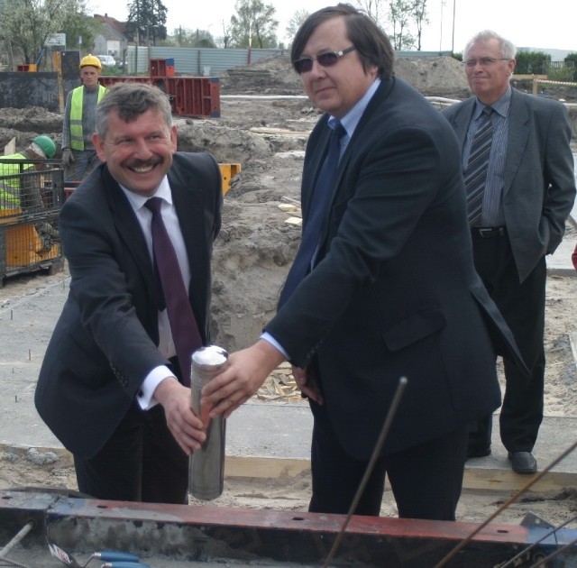 Andrzej Zabłocki i przedstawiciel wykonawcy wmurowują kamień węgielny pod nową inwestycję.