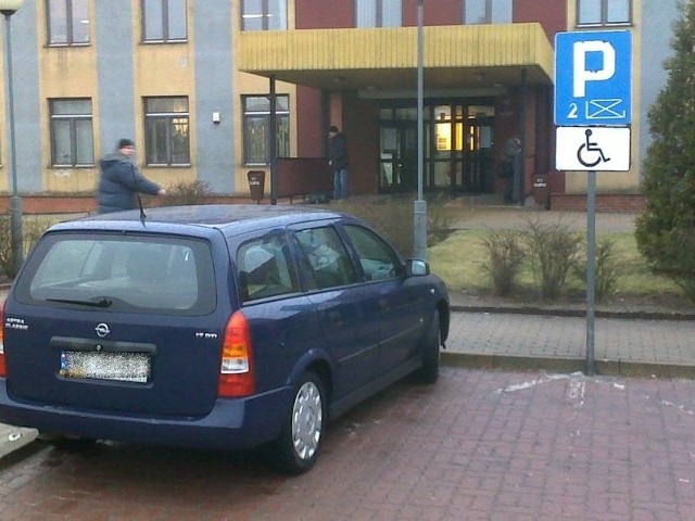 Opel zaparkowany na miejscu dla osoby niepełnosprawnej.